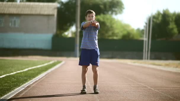 Мальчик-подросток занимался упражнениями на растяжку стадиона — стоковое видео