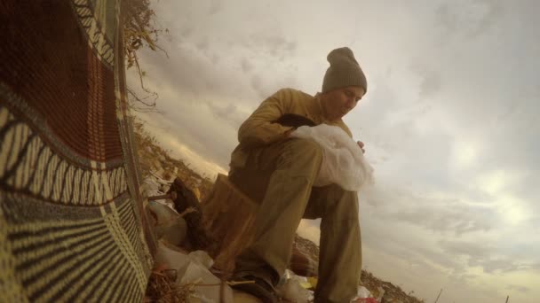 Arbeitslose entsorgen obdachlose, dreckig aussehende Lebensmittelabfälle in einer Männerdeponie Sozialvideo — Stockvideo