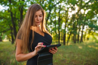 a woman of European appearance twenty years holding a tablet in