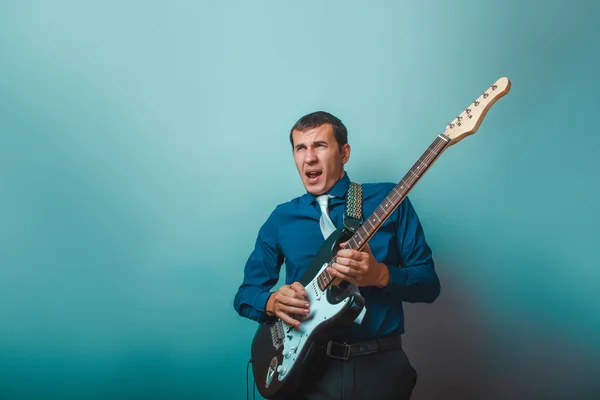 A  man of European  appearance thirty years of playing guitar on — Stock Photo, Image