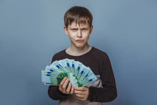 Boy  teenager European appearance ten years holding a wad  of mo — Stock Photo, Image