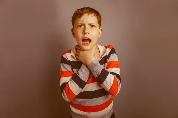 European-looking boy of ten years strangles himself hands on a g — Stock Photo, Image