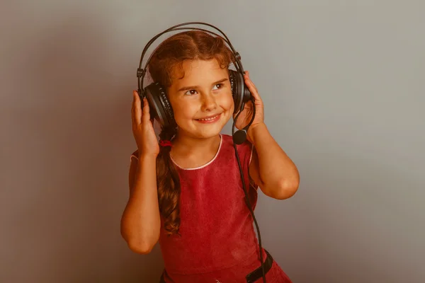 Dívka Evropského vzhledu desetiletí poslechu hudby s headphon — Stock fotografie