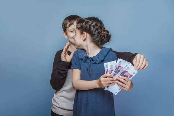 Girl holding money bills in the hands of a boy trying to take  a — Φωτογραφία Αρχείου