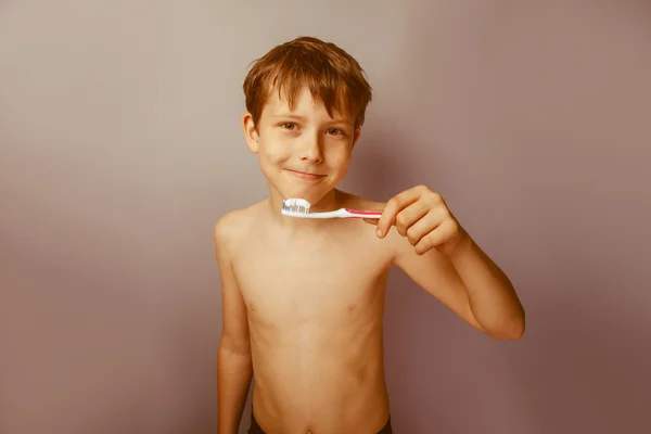 Een jongen van 10 jaar van Europees uiterlijk naakte torso borstelen hij — Stockfoto