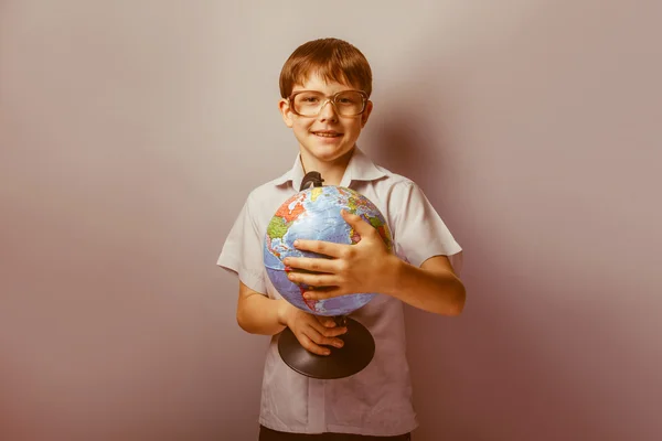 Un chico de 10 años de apariencia europea con gafas sosteniendo un —  Fotos de Stock