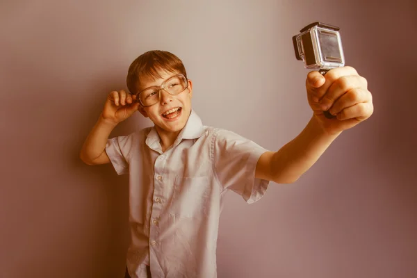 A boy of 10 years of European appearance with glasses holding a — Stock Photo, Image