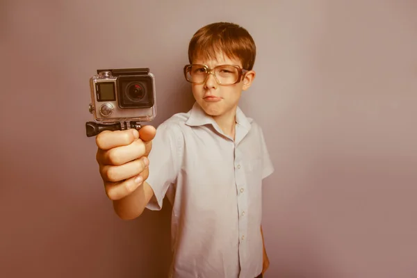 Un ragazzo di 10 anni di apparenza europea con gli occhiali che tengono un — Foto Stock