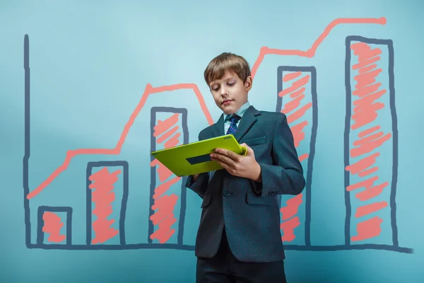 A boy of twelve European appearance in a suit holding a blank sh — Stock Photo, Image