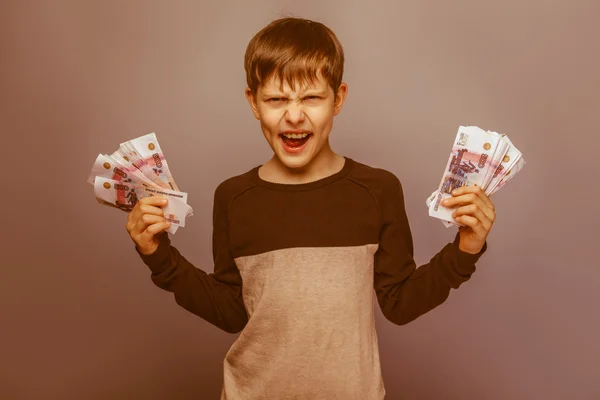 Boy teenager ten years  European appearance holding a wad  of mo — Stock Photo, Image