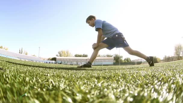 Adolescente haciendo entrenamiento de niño futbolista atleta se sienta en una gimnasia deportiva hierba — Vídeos de Stock