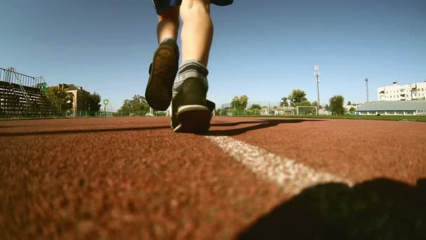 Atleta adolescente chico corredor corriendo en el estadio de la cinta de correr sol día soleado estilo de vida saludable — Vídeo de stock