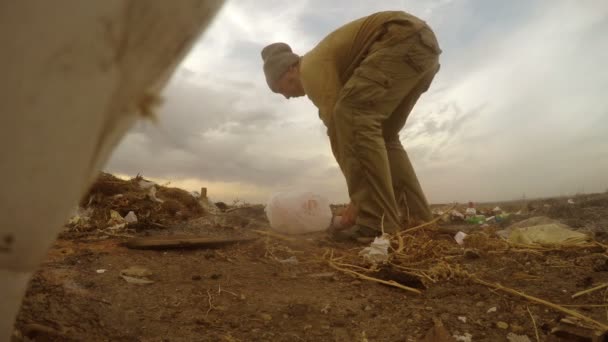 Desempleado volcado hombre sin hogar sucio buscando comida desperdicio en un relleno sanitario social video — Vídeos de Stock