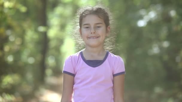 Tiener meisje portret van een groene achtergrond aard wild bos zonlicht valt schattig — Stockvideo