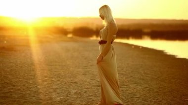 Gün batımı gülümseyen seksi sarı çölde kum dans kadın baştan çıkarıcı genç kız