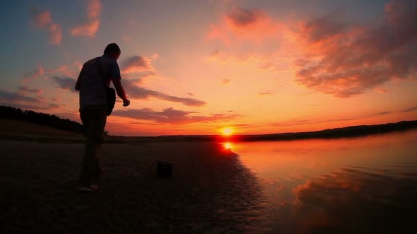 Guitarrista músico hombre macho conectar un cable eléctrico y comienza a jugar junto al río al atardecer color cielo — Vídeos de Stock