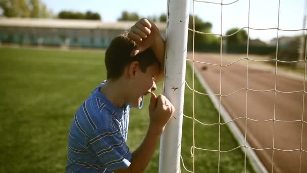 Teen upset defeat boy by knocking goal goal post net stadium turf — Stock Video