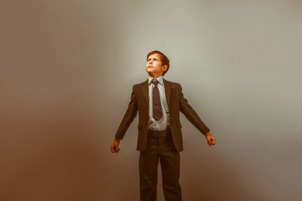 En pojke på tolv europeiskt utseende i kostym hålla sina händer — Stockfoto