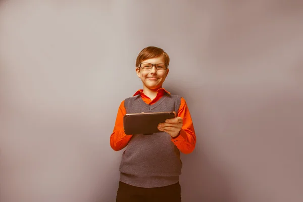 Europejskiej - Szukam chłopiec dziesięć lat w okularach trzymając tabletkę i — Zdjęcie stockowe