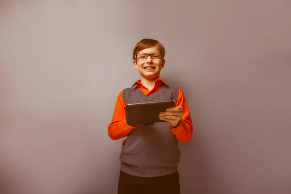 Chico de aspecto europeo de diez años en gafas sosteniendo la tableta —  Fotos de Stock