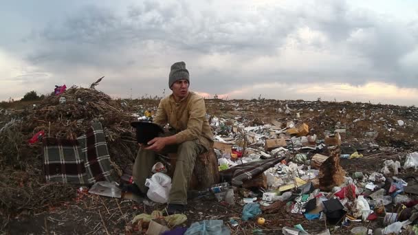 Man dump werklozen dakloze vuile voedselafval op stortplaatsen sociale video — Stockvideo