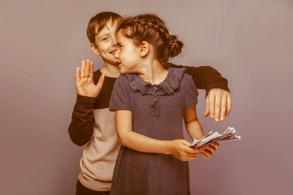 Girl holding money bills in the hands of a boy trying to take aw — Stock Photo, Image