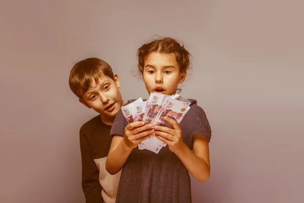 Girl holding money bills in the hands of the boy opened his mout — Stock Photo, Image