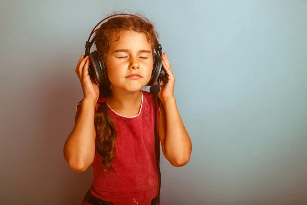 Teen dziewczyna dziecka oczy zamknięte, słuchając muzyki z wielkim headphon — Zdjęcie stockowe