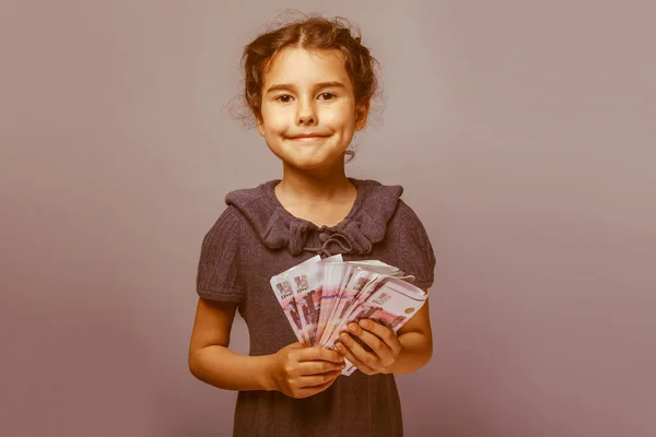 Teen girl of European appearance holds five denominations of mon — Stock Photo, Image
