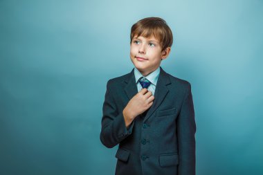European appearance teenager boy in a business suit straightens