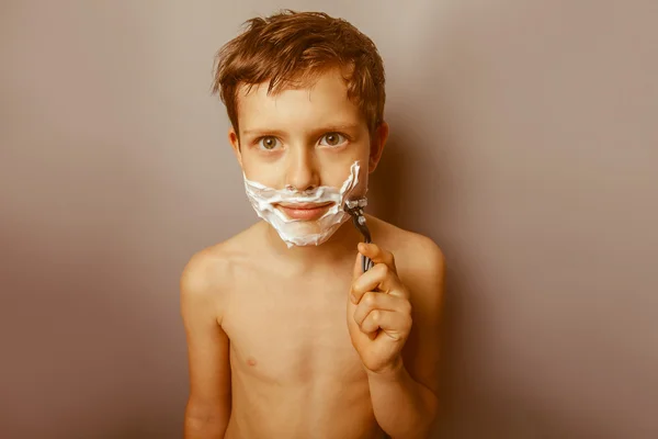 Tiener 12 jaar van Europese verschijning met een scheermes scheert — Stockfoto