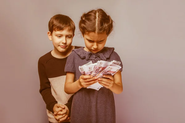 Teenage boy and girl  holding  money bills in his  hands on a  g — Stock Photo, Image