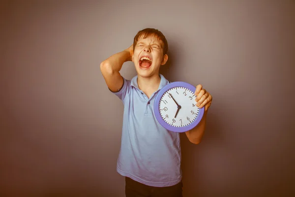 Adolescente chico marrón europeo apariencia sostiene un reloj cerrado su —  Fotos de Stock