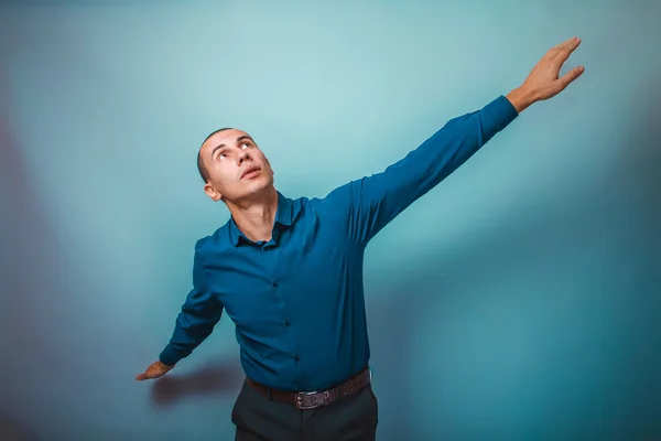 A man in a blue shirt European appearance spread his arms in a p — Φωτογραφία Αρχείου