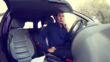 arabada mavi gömlekli adam telefonda konuşurken nasıl yol almak için açıklar