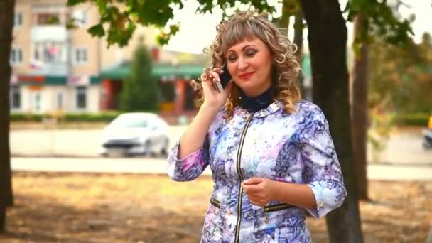 Mujer completa grasa de mediana edad en el teléfono en el parque detrás de los coches estilo de vida de conducción — Vídeos de Stock