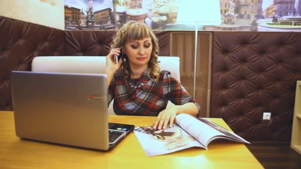 Thick fat woman in a cafe reading magazine Journal works for laptop Internet freelancer average age of lifestyle — Stock Video