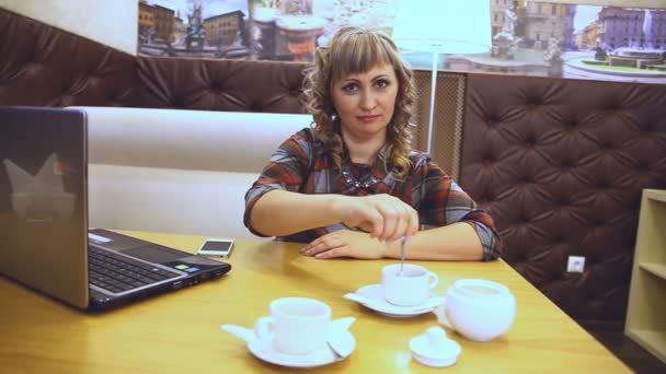 Átlagos életkora egy nő vastag kávét iszik egy kávézóban dolgozó egy laptop szabadúszó életmód — Stock videók