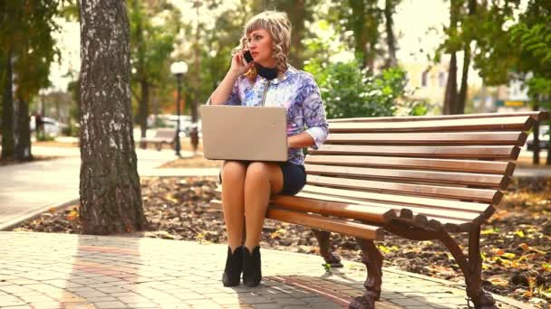 Middle-aged woman full of fat sitting on park wind bench working at laptop freelancer distant work business — Stock Video