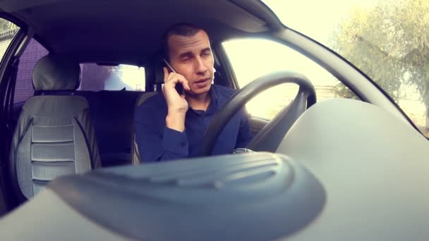 Gerente hombre de negocios conducir un coche y hablar en un teléfono móvil habla — Vídeo de stock