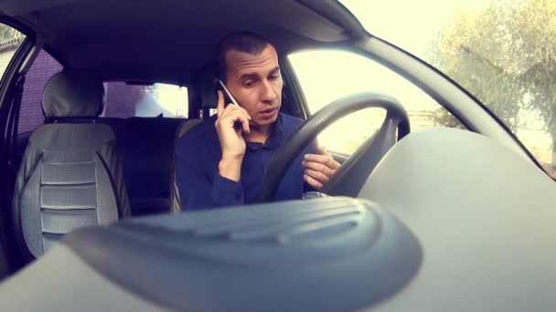 Gerente hombre de negocios conducir un coche y hablar en un teléfono móvil negocia guarda documentos — Vídeo de stock