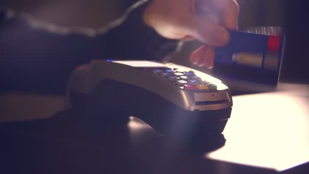 Asistente de tienda insertando una tarjeta de crédito en pos y arrancando una gran noche de luz de fondo de recibo — Vídeos de Stock