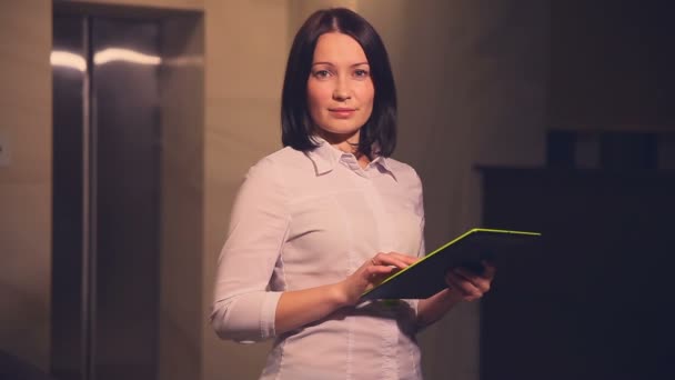 Молода бізнес-леді менеджер готелів в ліфті з планшетним ПК — стокове відео