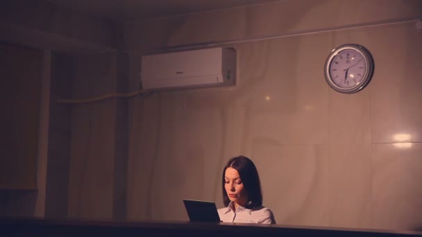 Young administrator woman at the reception giving keys hotel It is working on a tablet — Stock Video