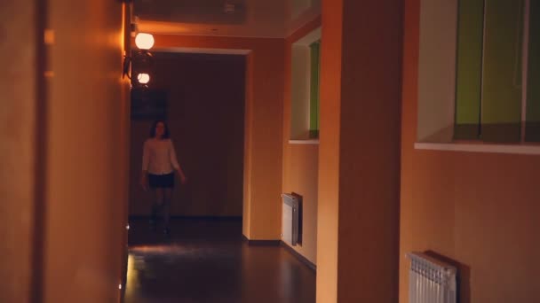 Werknemer van hotelmanager is een vrouw in de avond langs de corridor geel licht — Stockvideo