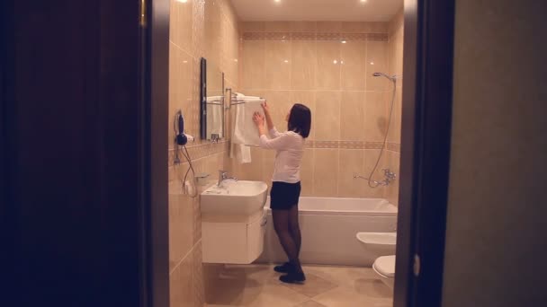Maid makes woman cleaning bathroom towel straightens — Stock Video