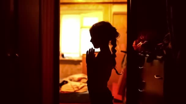Tini lány imádkozott sziluettje egy folyosó barna este vallás — Stock videók