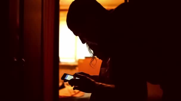 Fille adolescent papa fille recherche smartphone jeu sur Internet dans le couloir intérieur jaune brun silhouette — Video