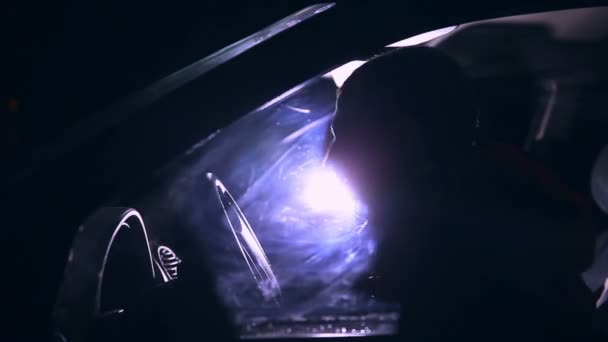 Ember ül az autóban, éjjel, és megérinti a kék fény megy — Stock videók