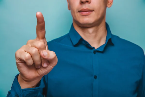 Een man kan worden gezien helft-gezicht toont een vinger op een grijze achtergrond — Stockfoto